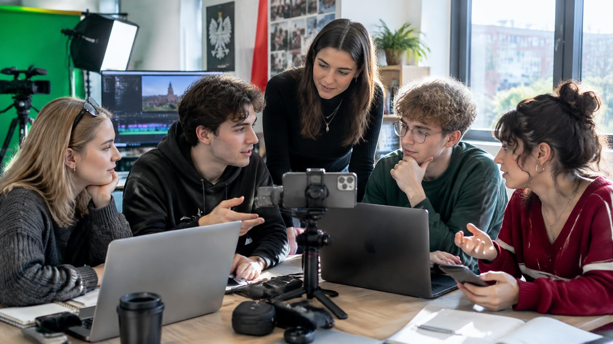 Group of young creators collaborating in a bright media studio